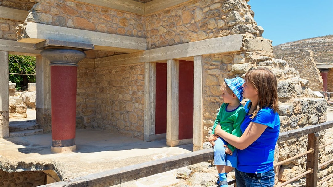 Family exploring Knossos Palace ruins in Crete, Greece.