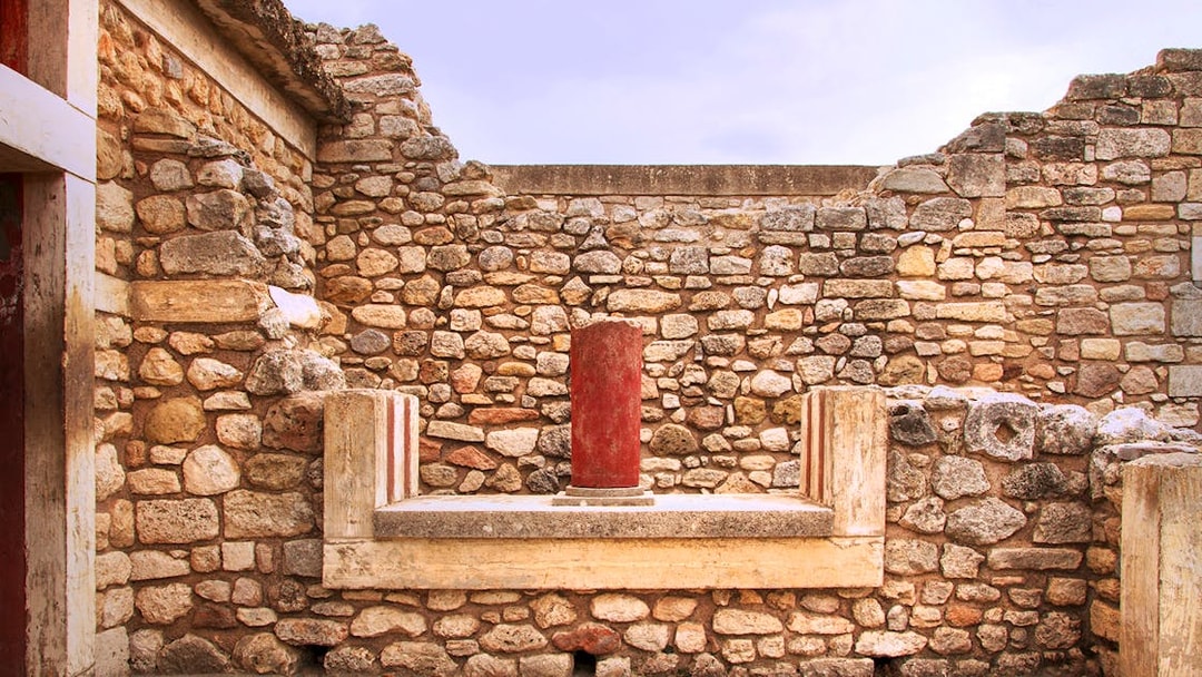 Knossos Palace stone wall with red column in Crete, Greece.