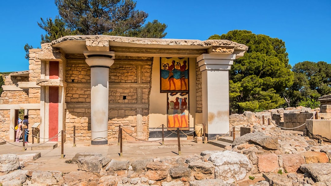 Knossos Palace frescoes and ruins in Crete, Greece, with visitors exploring the site.