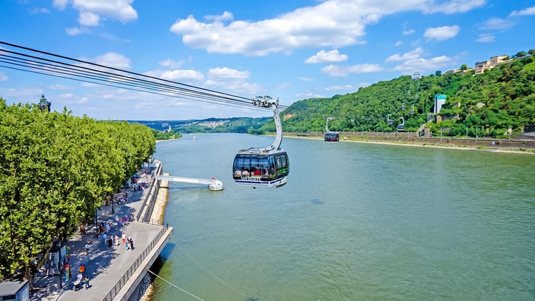 Koblenz Cable Car crossing the Rhine River with views of lush green hills.
