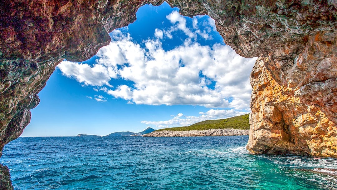Blue cave entrance with view of Montenegro coast and clear sea.