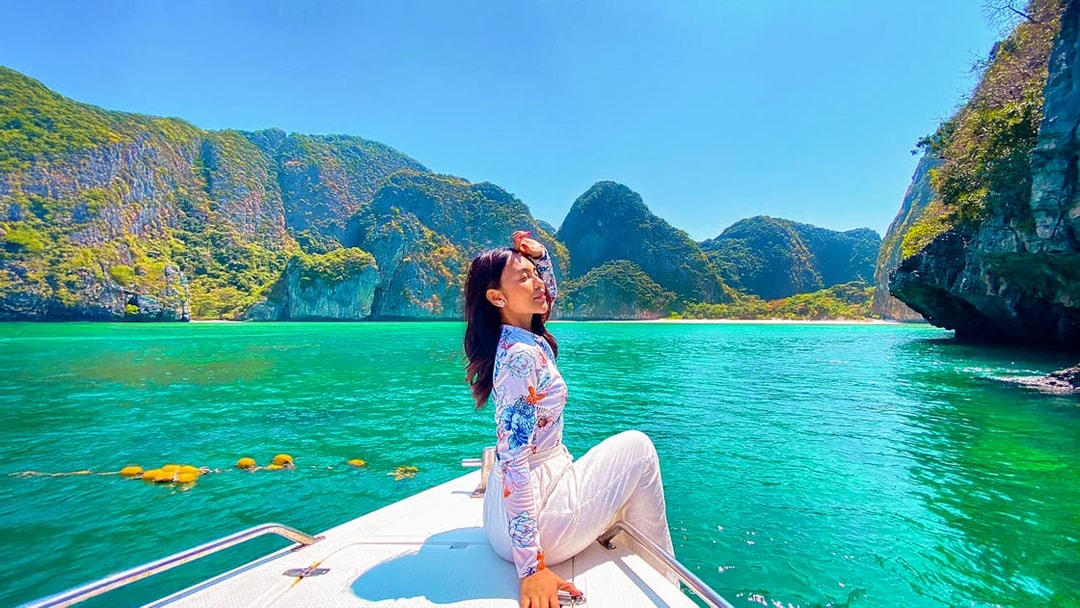 Woman enjoying a boat ride in Krabi with view of Phi Phi Islands.