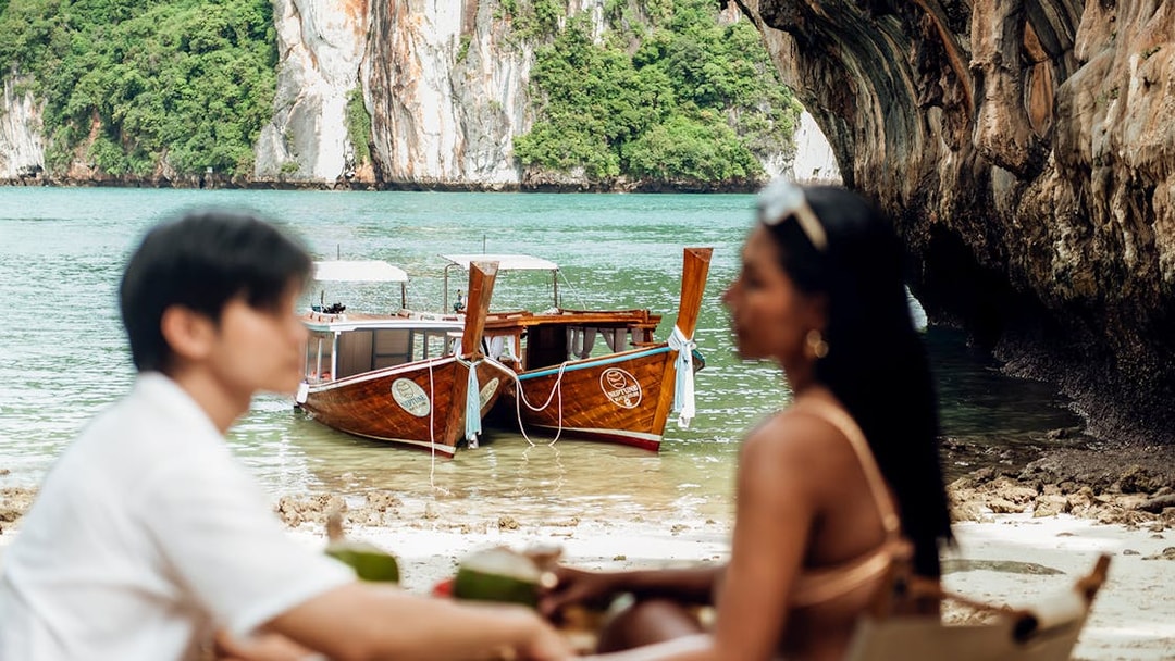 Longtail boat anchored near Krabi limestone cliffs, part of Neptune Boat & Leisure private charter.