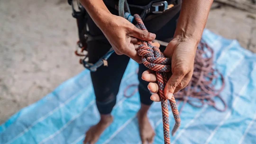 Climber tying a knot during Krabi rock climbing course at Railay.