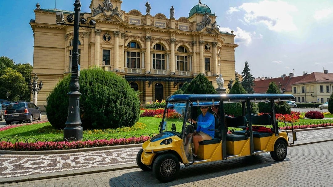 Electric car tour passing by the Juliusz Słowacki Theatre in Krakow.