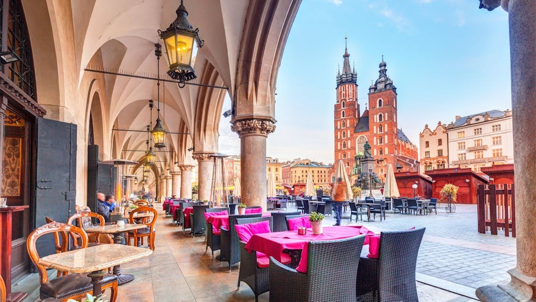 Outdoor café under arches with view of St. Mary's Basilica in Krakow, Poland.