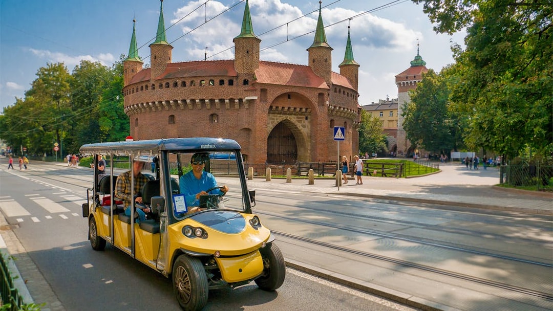 Electric car tour passing Krakow's historic Barbican.