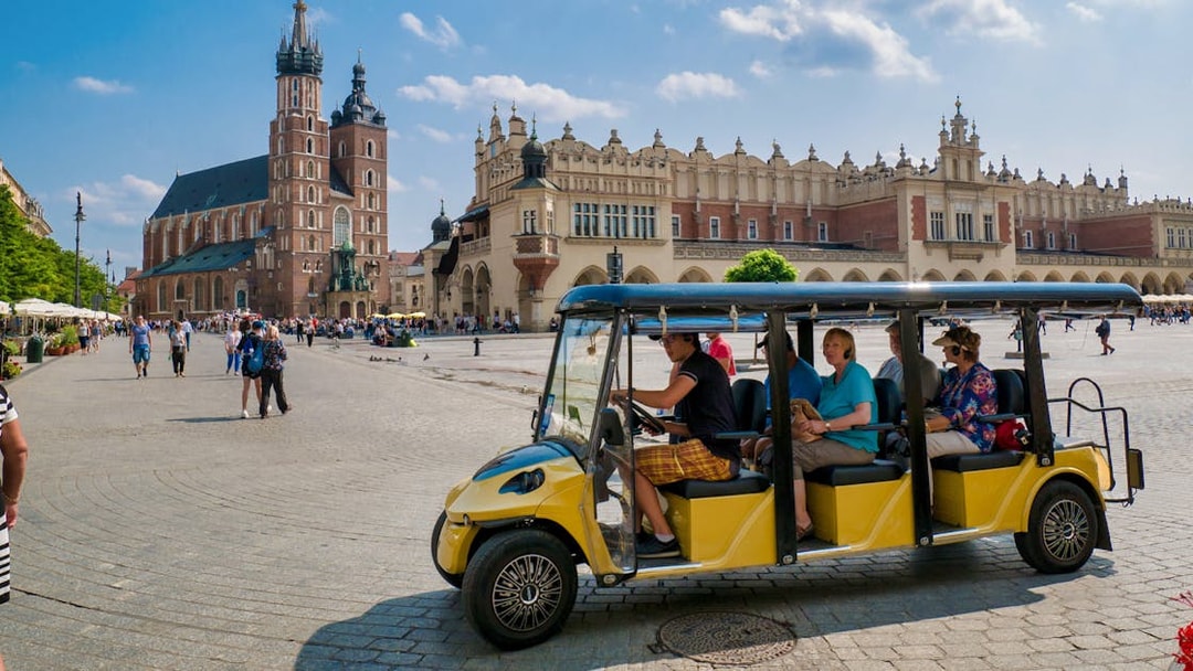 Electric car tour in Krakow's Main Square with St. Mary's Basilica in the background.