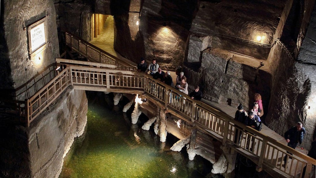 Visitors exploring the underground wooden walkway at Wieliczka Salt Mine.