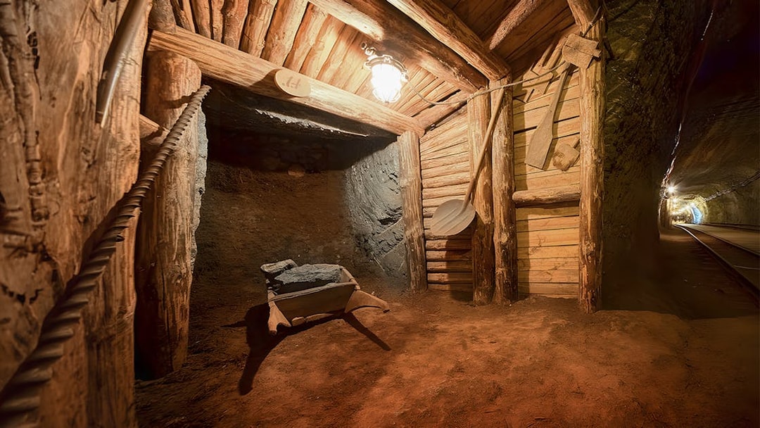 Underground wooden tunnel in Bochnia Salt Mine with mining tools and dim lighting.
