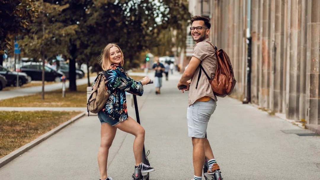 Two people on e-scooters during a city sightseeing tour.