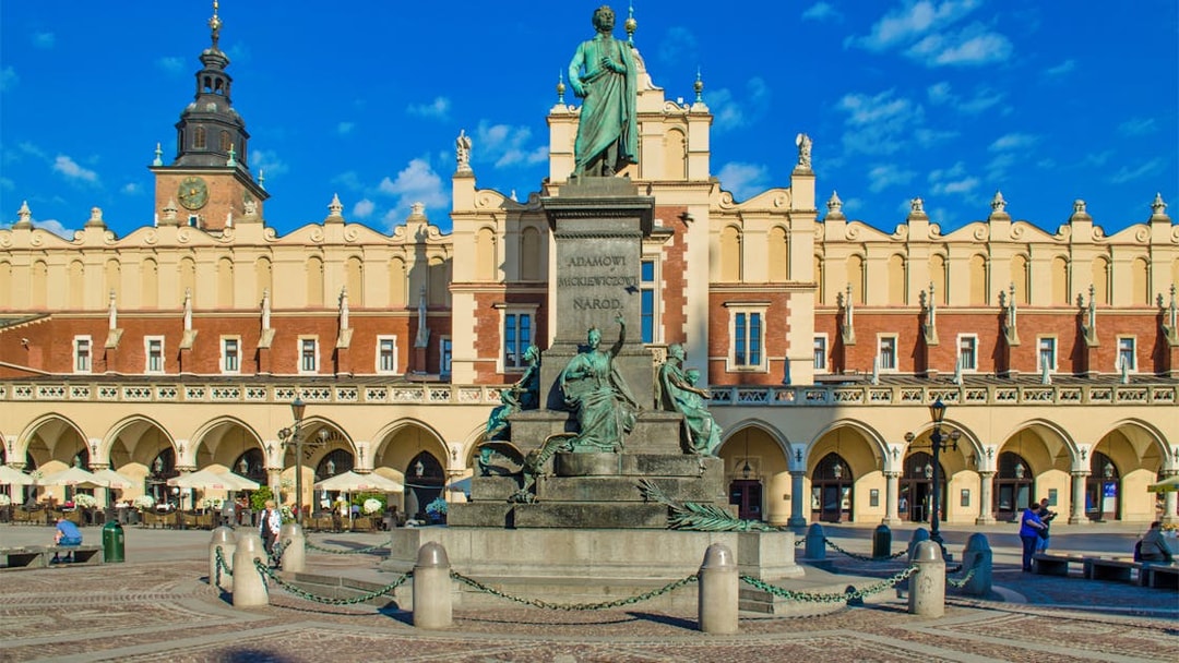 Statue of Adam Mickiewicz in front of Cloth Hall, Krakow, on a guided e-scooter tour.