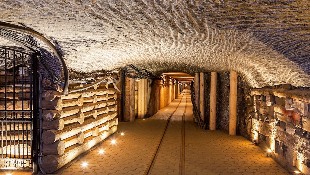 Wieliczka Salt Mine underground passageway with illuminated walls and wooden supports.