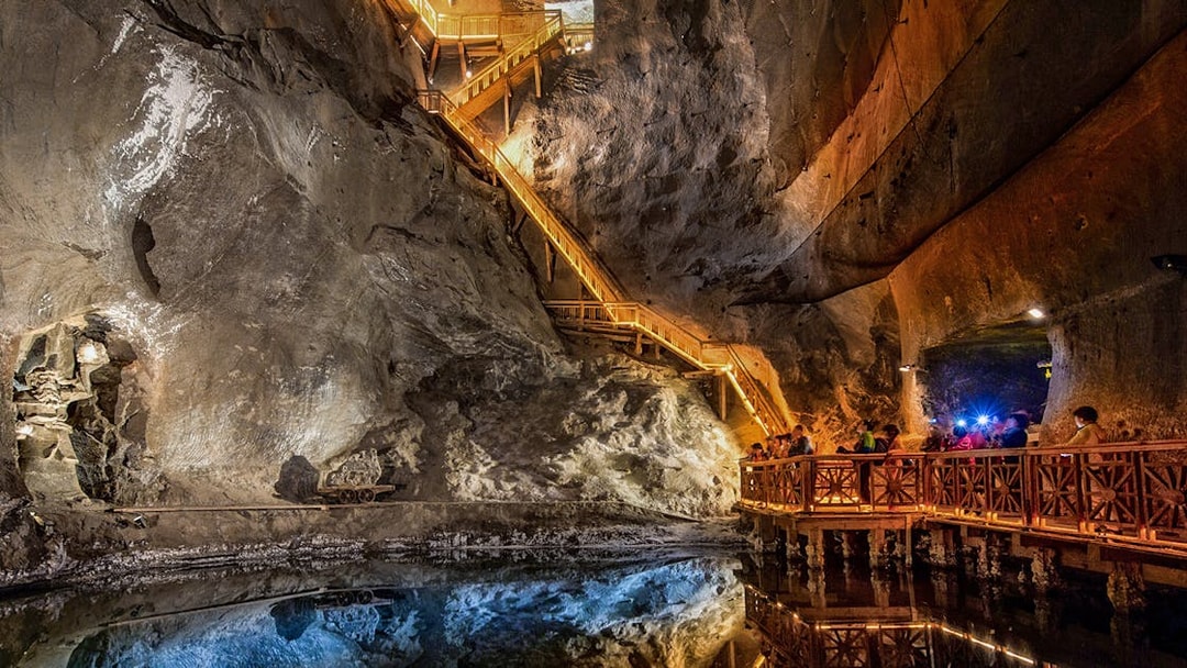 Visitors exploring the illuminated salt lake in the Wieliczka Salt Mine, Poland.