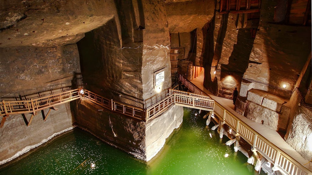 Wieliczka Salt Mine underground salt lake with wooden walkways and illuminated rock walls.