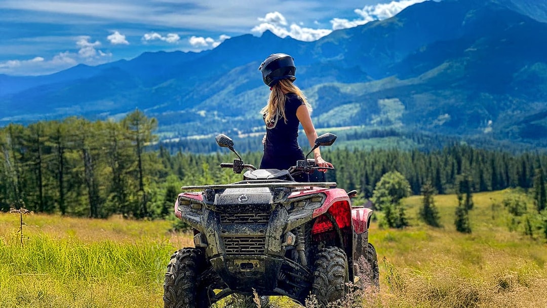 Visitor on quad bike overlooking Zakopane mountains and forest.