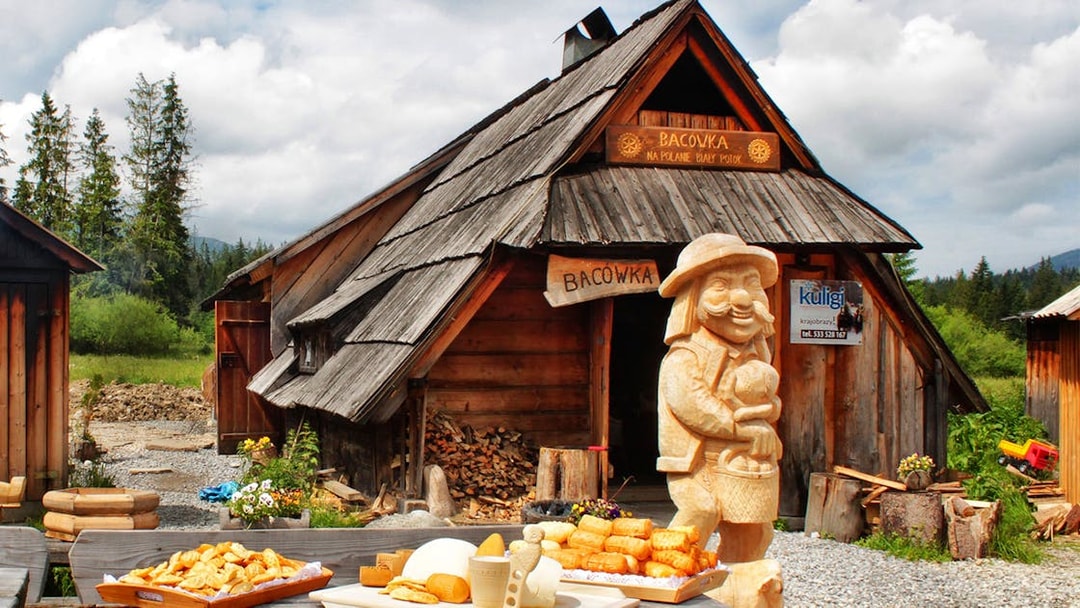 Wooden hut in Zakopane with traditional cheese display and carved figure.