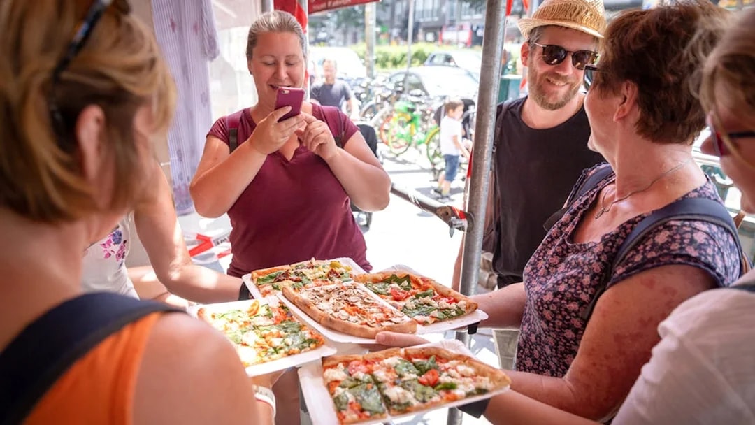 Tour group enjoying pizza on a guided food tour in Kreuzberg.