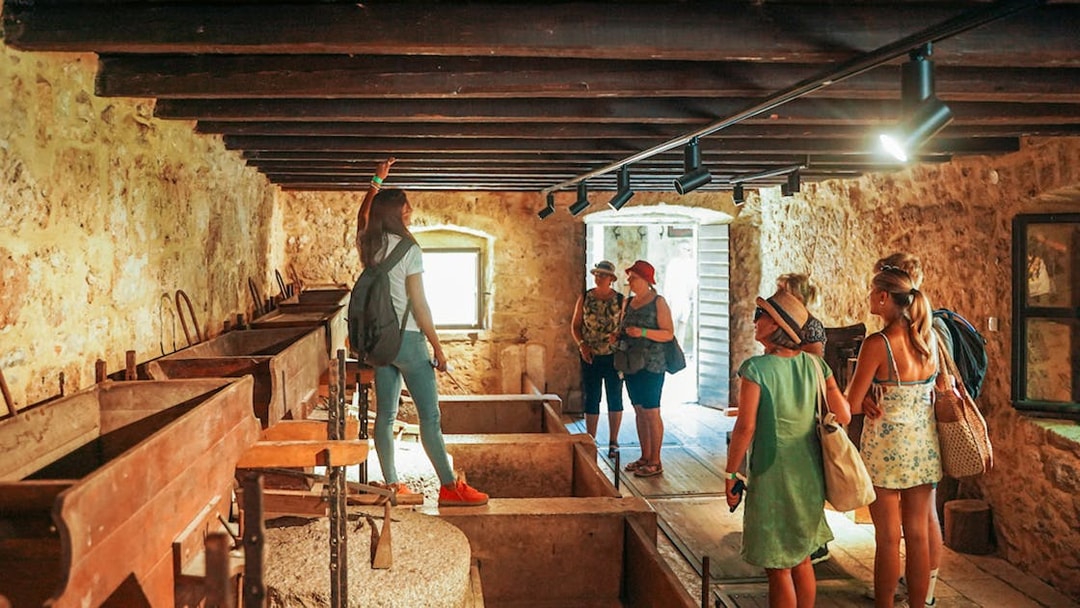 Visitors exploring a historic stone building in Krka National Park.
