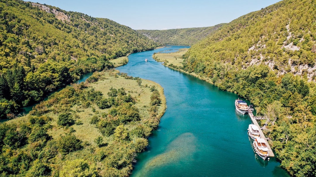 Boat on Krka River surrounded by lush greenery in Krka National Park, Croatia.