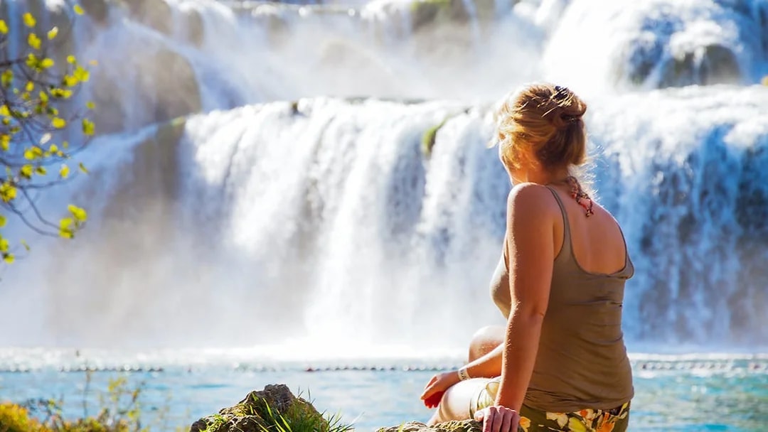 Visitor enjoying the view of waterfalls at Krka National Park, Croatia.