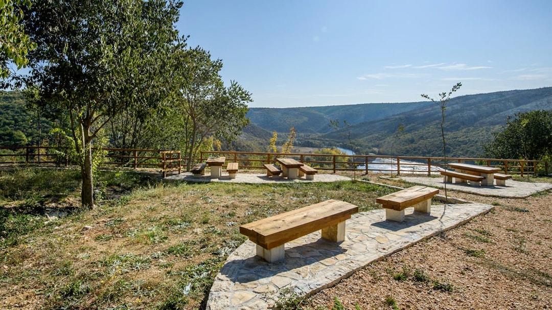 Seating area overlooking river and hills at Krka National Park viewpoint.