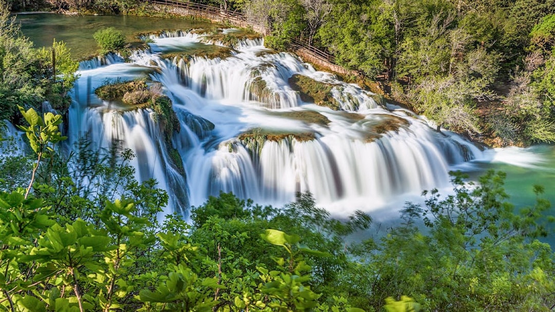 Waterfalls at Krka National Park surrounded by lush greenery.