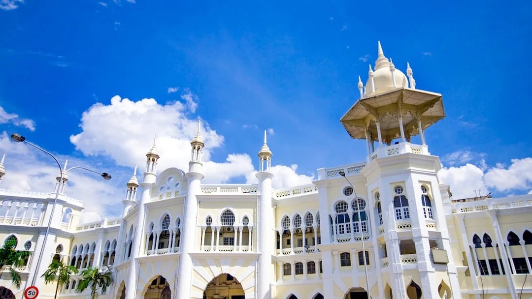Kuala Lumpur Railway Station with Moorish architecture under blue sky.