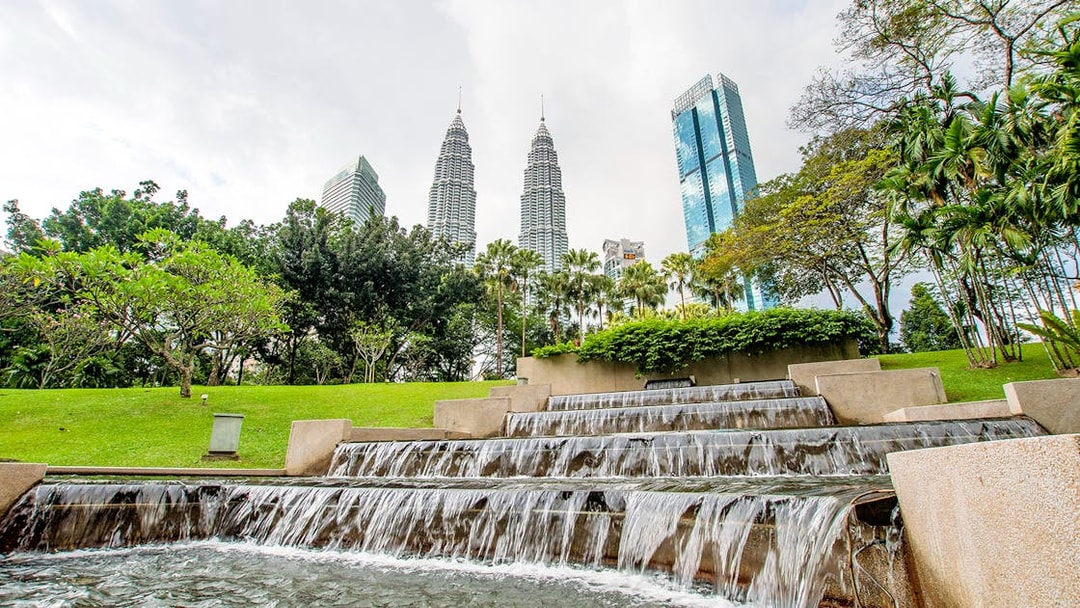Petronas Towers and park waterfall in Kuala Lumpur, Malaysia.