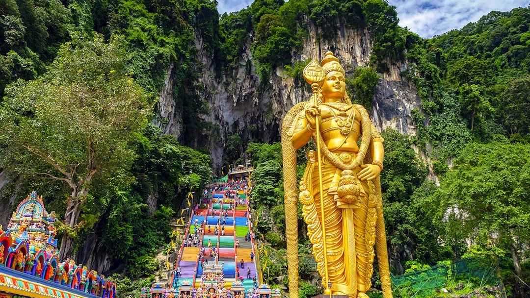 Golden Lord Murugan statue and colorful steps at Batu Caves, Malaysia.