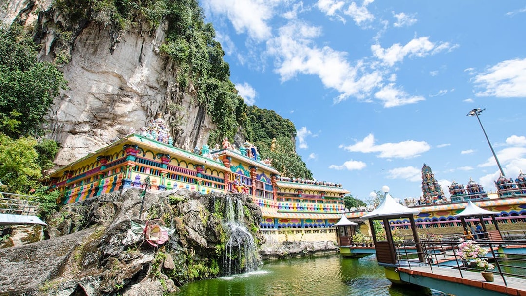 Batu Caves temple complex with colorful facade and surrounding limestone cliffs in Kuala Lumpur.