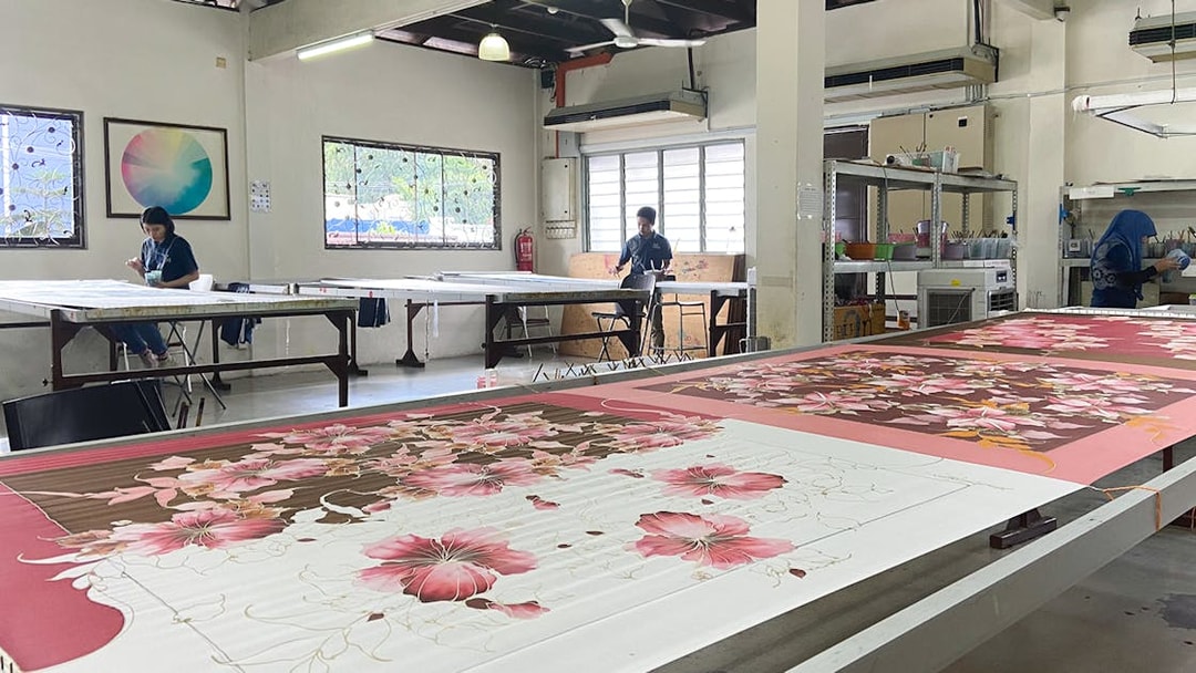 Batik painting demonstration at Royal Selangor Pewter factory with artists at work.