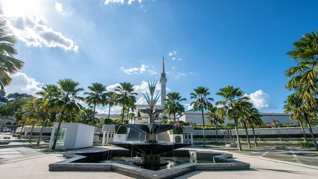 National Mosque of Malaysia with fountain and palm trees, Kuala Lumpur.