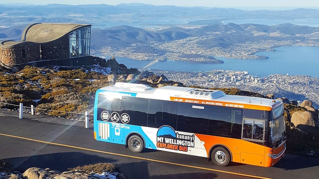Kunanyi/Mt Wellington Explorer Bus with Hobart view in background.