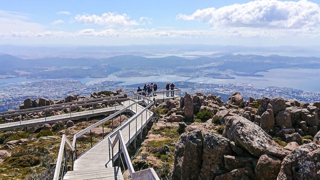 Kunanyi Mt Wellington view with visitors on boardwalk overlooking Hobart, Tasmania.