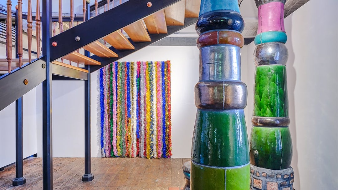 KUNST HAUS WIEN Antimatter Factory exhibit with colorful vertical art and unique architectural columns.