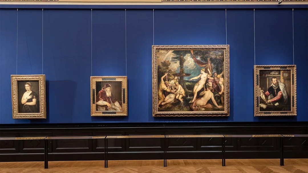 Paintings displayed on a blue wall inside Kunsthistorisches Museum, Vienna.