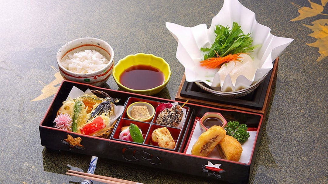 Traditional Japanese bento with rice, tempura, and vegetables on Kyoto Sagano Romantic Train Day Tour.
