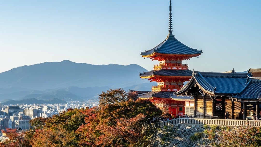 Kiyomizu-dera Temple with autumn foliage and cityscape in Kyoto, Japan.