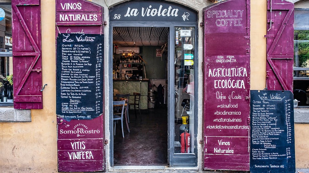Entrance to La Violeta restaurant in La Barceloneta with menu boards displaying local dishes.