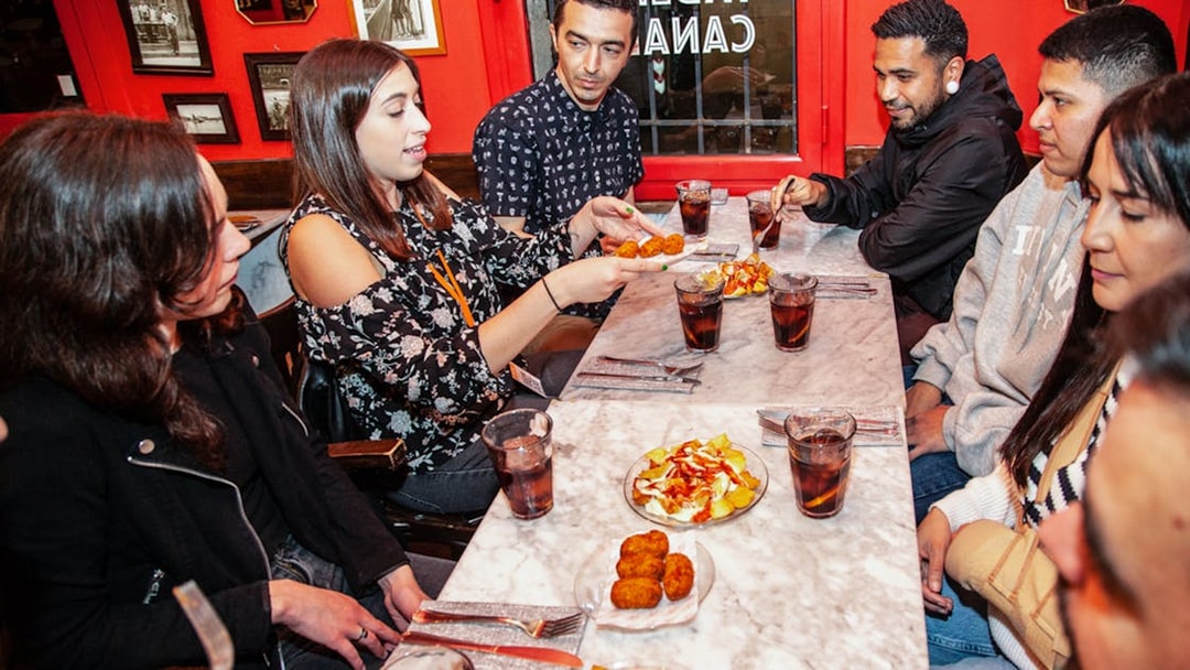 Group enjoying tapas at a table during a 3-hour guided food tour in La Barceloneta.