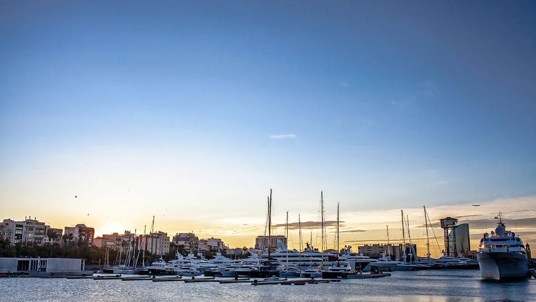 La Barceloneta harbor with yachts at sunset during a 3-hour guided food tour.