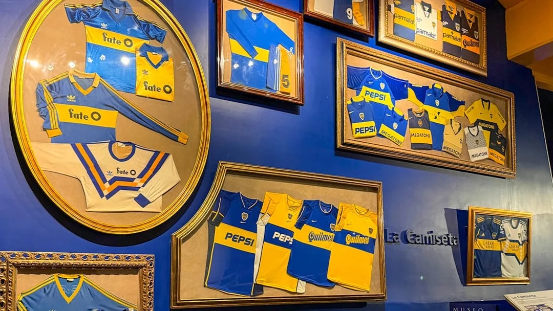 Framed Boca Juniors jerseys displayed inside La Bombonera stadium museum.