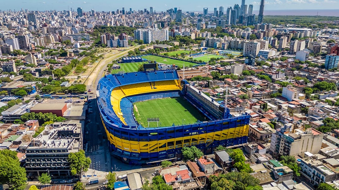 Aerial view of La Bombonera stadium in Buenos Aires, home of Boca Juniors, surrounded by cityscape.