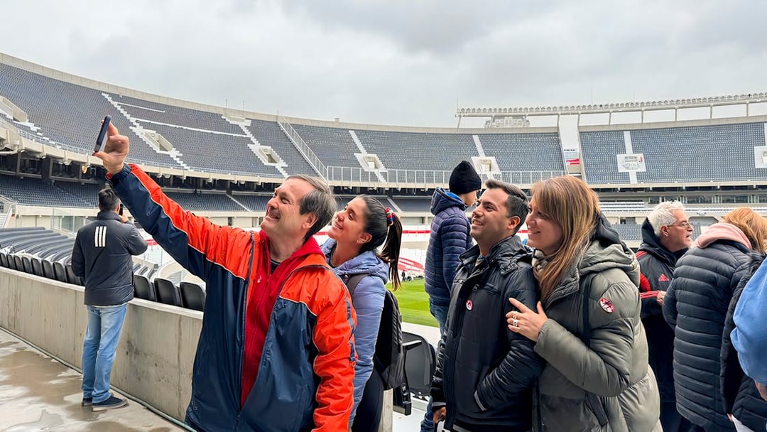 Tourists with guide taking photos at La Bombonera stadium in Buenos Aires.