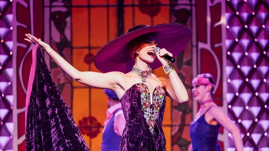 Performer singing at Cabaret La Nouvelle Eve in Paris.