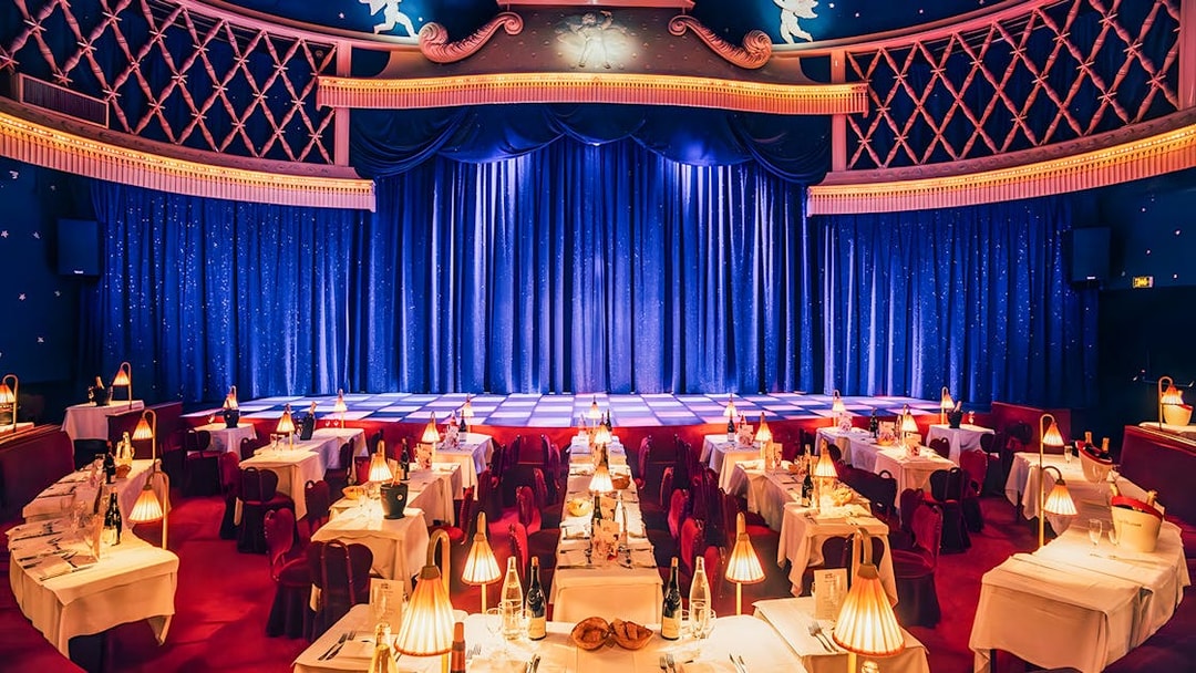 Cabaret La Nouvelle Eve stage with tables set for a champagne spectacle in Paris.