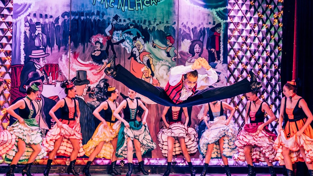 Dancers performing at Cabaret La Nouvelle Eve in Paris with vibrant costumes.