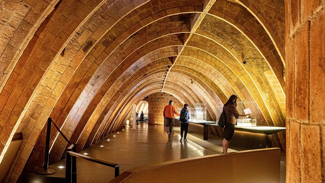 Casa Mila attic with visitors exploring Gaudi's architectural arches in Barcelona.