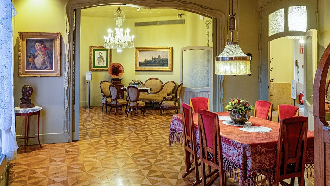 La Pedrera Casa Mila dining room with ornate chandelier and vintage furniture.
